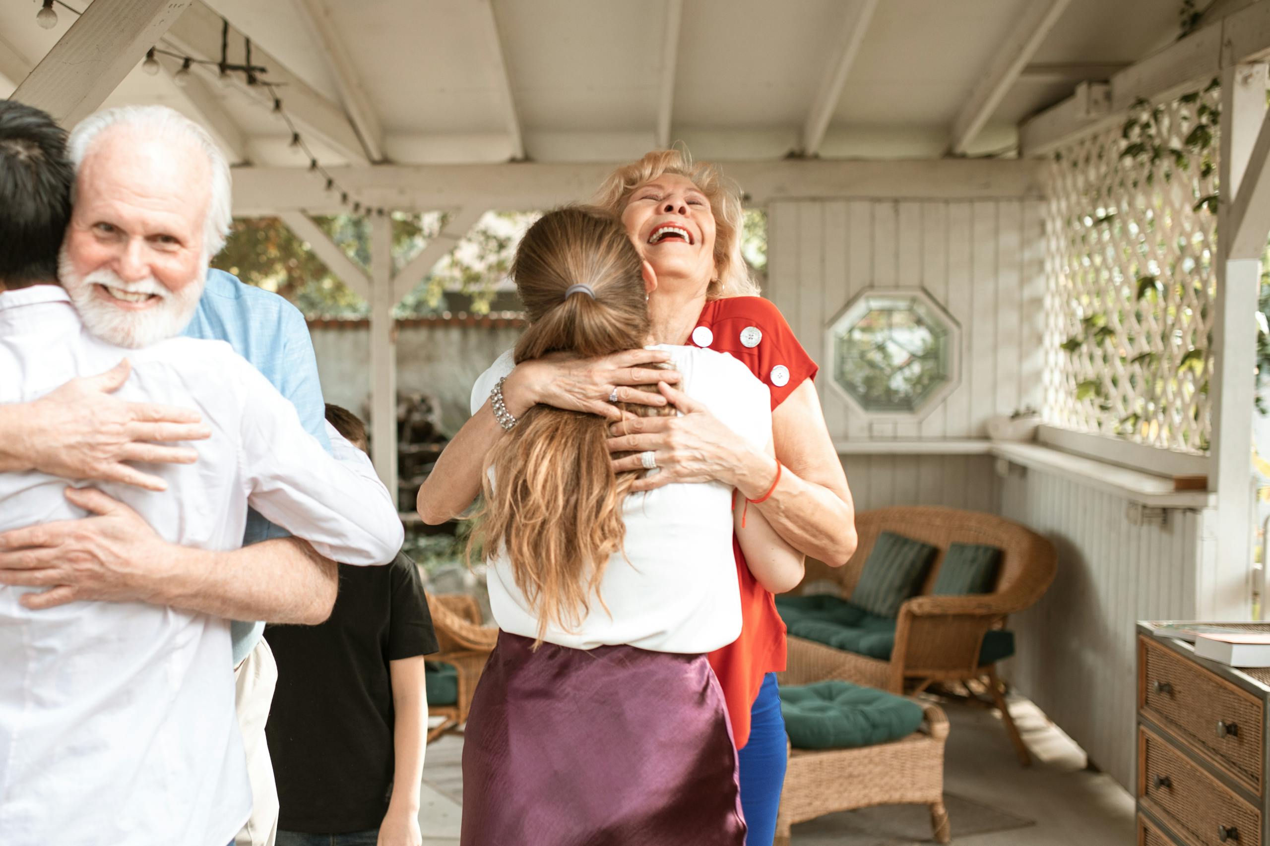 A heartwarming reunion with family members hugging and smiling in a cozy indoor setting.