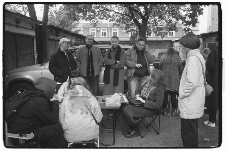 An intimate street scene of people gathered outdoors in a relaxed setting.