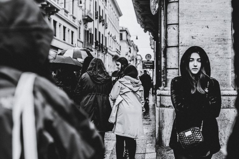 Black and white city street scene with people on a rainy day.
