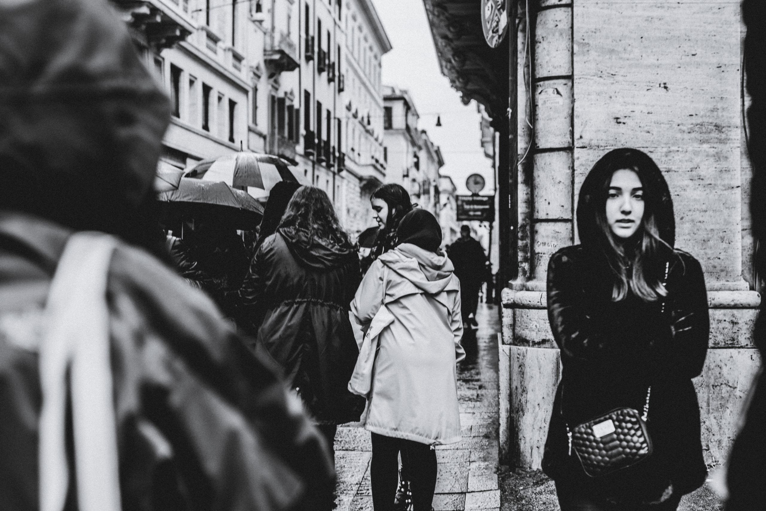Black and white city street scene with people on a rainy day.