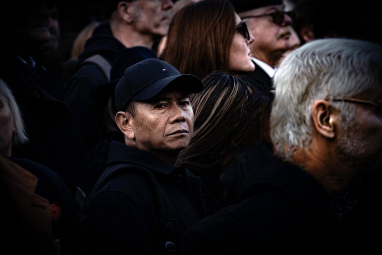 Candid street photograph capturing diverse crowd with a focus on an intense gaze from a central figure.
